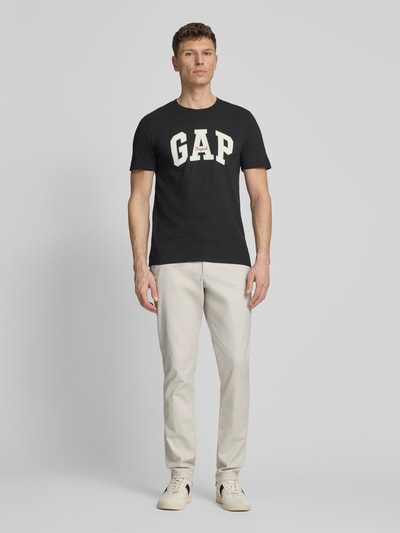 Männermodel trägt Slim Fit Chino mit Eingrifftaschen von GAP, heller Baumwoll-Elasthan-Mix, Ganzkörperansicht von vorne, Herren.