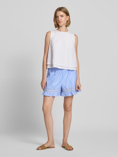 Frauenmodel trägt Regular Fit Shorts mit Loch-Stitching Modell 'Amansa' von Neo Noir aus Baumwoll-Mix in Hellblau, elastischer Bund, Rüschenbesatz, Ganzkörperansicht von vorne.