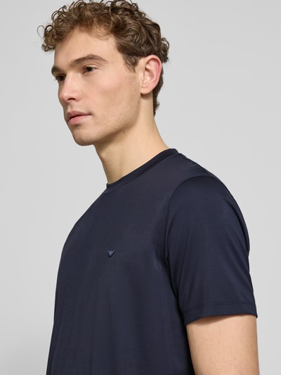 Männermodel trägt Regular Fit T-Shirt mit Rundhalsausschnitt von Emporio Armani, dunkelblau, glatte Textur, Nahaufnahme Oberkörper. Modal-Mix mit Belseta, kurzärmelig, Rückenlänge bei Größe M 71 cm.