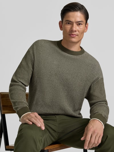 Männermodel trägt Regular Fit Strickpullover aus reiner Baumwolle von HECHTER PARIS in Olivgrün, Rundhalsausschnitt, Nahaufnahme Oberkörper.