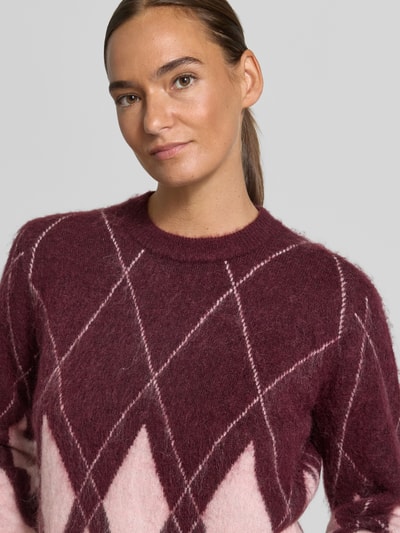 Kobiece model prezentuje Regular Fit Pullover aus Woll-Mix von Jake*s Casual w odcieniach bordowym i różowym, tekstura dzianiny, zbliżenie na górną część ciała.