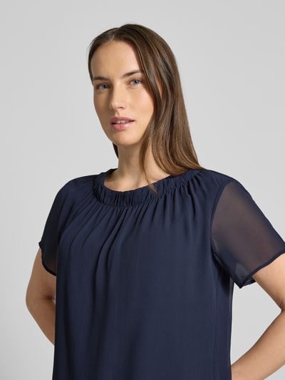 Kobiece model prezentuje Regular Fit Blusenshirt mit semitransparenten Ärmeln od s.Oliver BLACK LABEL, ciemnogranatowy, krój regular fit, dekolt okrągły, półprzezroczyste krótkie rękawy z szyfonu, struktura gładka, widok na górną część ciała z przodu.