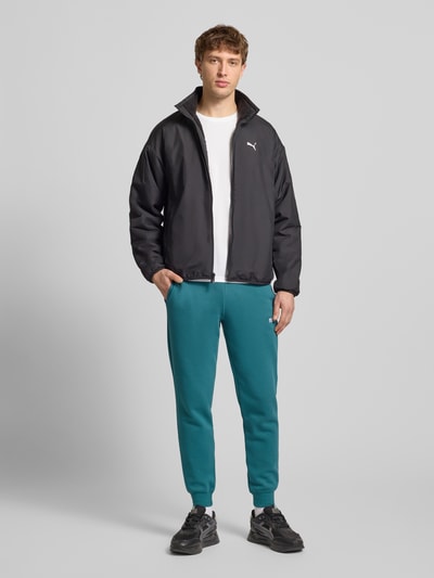 Männermodel trägt T-Shirt mit Logo und Rundhalsausschnitt von PUMA PERFORMANCE, weiß, Regular Fit, Ganzkörperansicht von vorne.