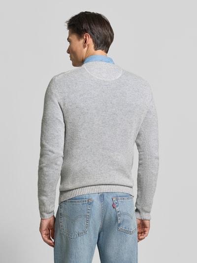 Männermodel trägt Slim Fit Strickpullover aus reiner Wolle mit Label-Stitching von MCNEAL, gerippte Abschlüsse, Rückansicht, Ganzkörperansicht Rückansicht.