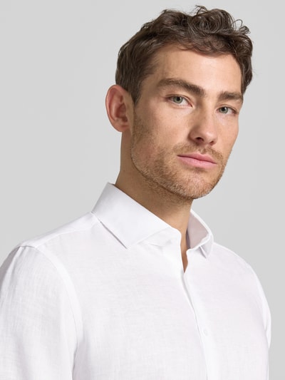 Männermodel trägt Regular Fit Leinenhemd mit Kentkragen von Christian Berg Men in Weiß, feine Leinenstruktur, Nahaufnahme Oberkörper.
