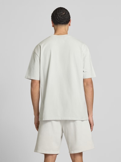Männermodel trägt Oversized T-Shirt mit Logo-Stitching van Pegador, pure katoen, oversized fit, ronde hals, ruglengte maat M 73 cm, Ganzkörperansicht Rückansicht.