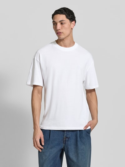 Männermodel trägt T-Shirt mit Rundhalsausschnitt Modell 'BRADLEY' von Jack & Jones in Weiß, Regular Fit, reine Baumwolle, Ganzkörperansicht von vorne.
