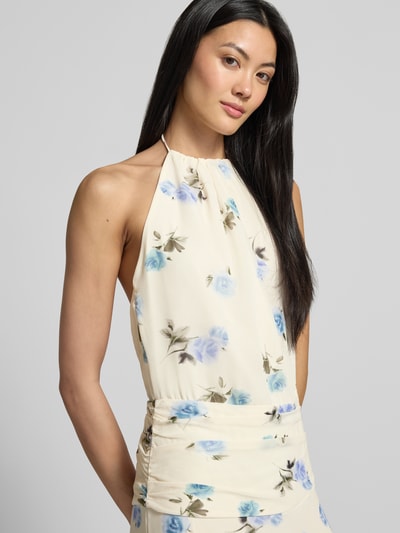 Frauenmodel trägt Maxikleid mit Neckholder Modell 'Gabina' von Neo Noir, cremig-beige mit blauem Blumenmuster, Chiffon, Nahaufnahme Oberkörper.