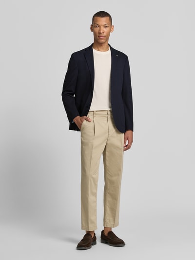 Męski model nosi Modern Fit Sakko mit Brustleistentasche od Pierre Cardin, kolor granatowy, bawełniana mieszanka, krój modern fit, kołnierz z klapami, kieszeń na lewej piersi, boczne kieszenie ukośne, jedno- i dwurzędowa listwa guzikowa, label detail, długość pleców w rozmiarze 50: 73 cm, szerokość ramion w rozmiarze 50: 40 cm, długość rękawa w rozmiarze 50: 63 cm, gładka faktura; pełna sylwetka z przodu.