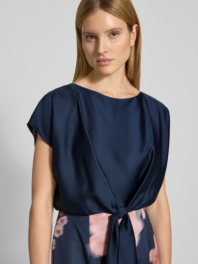 Vrouwenmodel draagt knielanges Cocktailjurk met knoopdetail van SWING, materiaalmix met stretch, recht model, ronde hals, Nahaufnahme bovenlichaam.