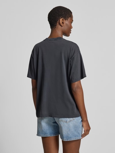 Frauenmodel trägt Relaxed Fit T-Shirt mit Logo-Print von Anine Bing, schwarze Reine Baumwolle, Rundhalsausschnitt, Kurzärmelig, Rückenlänge bei Größe S 59 cm, Ganzkörperansicht Rückansicht.