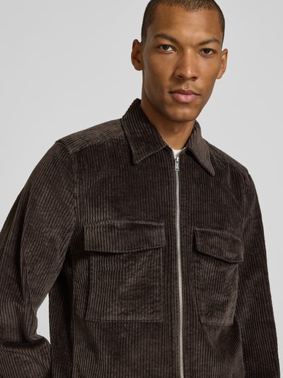 Männermodel trägt Regular Fit Cordjacke aus Baumwoll-Mix von DRYKORN, brauner Baumwoll-Elasthan-Mix mit Umlegekragen und Brusttaschen, Nahaufnahme Oberkörper.
