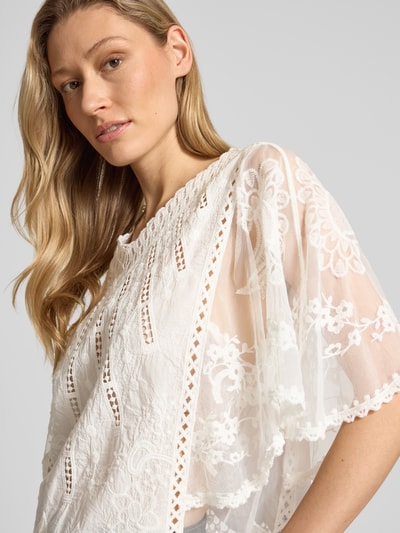 Frauenmodel trägt Blusenshirt aus Spitze von Apricot in Weiß, reine Baumwolle, V-Ausschnitt, Fledermausärmel, Spitze, Nahaufnahme Oberkörper.