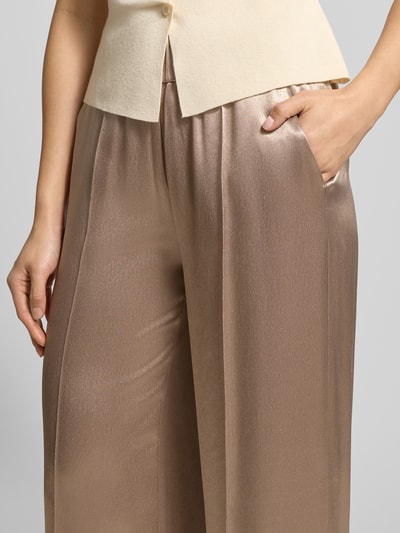 Kobiece model prezentuje Stoffhose mit elastischem Bund Modell 'Mucia' von OPUS PANTS, jasnobrązowa wiskoza, luźny krój, zbliżenie na górną część.