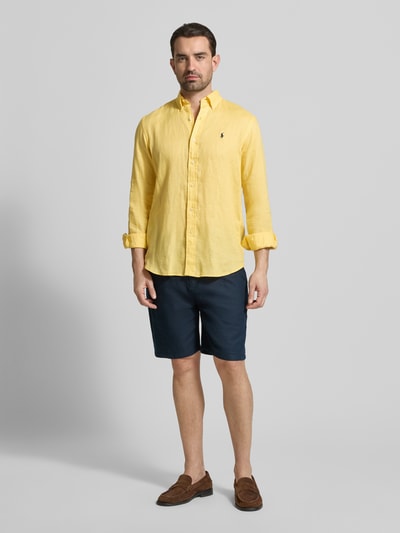 Männermodel trägt Regular Fit Freizeithemd aus reinem Leinen van Polo Ralph Lauren in effen geel, lange mouwen, geheel vooraanzicht