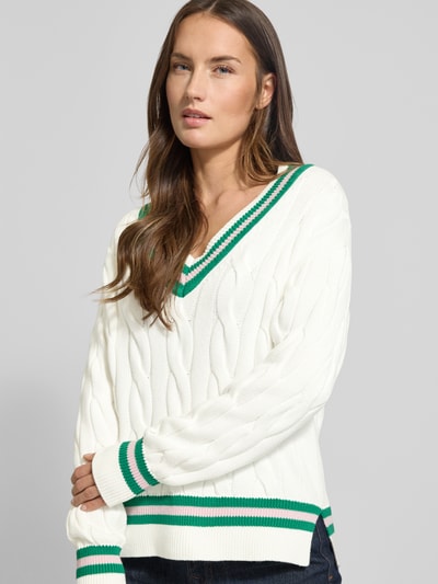 Modelka kobieca nosi Strickpullover mit V-Ausschnitt von Christian Berg Woman z bawełny, białe z zielonymi ściągaczami, regular fit, zbliżenie na górną część ciała.