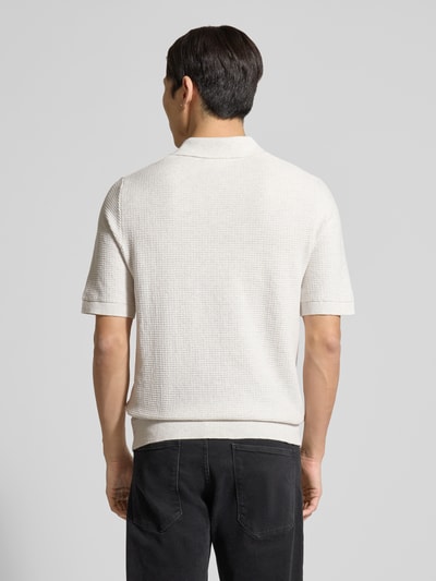 Männermodel trägt Regular Fit Poloshirt aus reiner Baumwolle von Tom Tailor in Strickoptik, helle Farbe, strukturierte Oberfläche, Ganzkörperansicht Rückansicht.