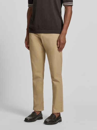 Męski model nosi Slim Fit Jeans im 5-Pocket-Design od Christian Berg Men, elastyczna mieszanka bawełny, beżowy kolor, krój slim fit, 5 kieszeni, zapięcie na guzik i zamek błyskawiczny, szerokość w rozmiarze 32/32: 42 cm, długość wewnętrzna nogawki: 82 cm, pełna sylwetka z przodu.