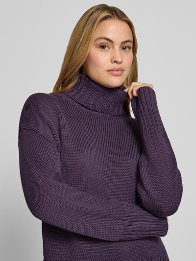 Frauenmodel trägt Relaxed Fit Strickpullover aus reiner Baumwolle mit Rollkragen von MOS MOSH in dunklem Lila, grobe Strickstruktur, Damen Strickpullover, Nahaufnahme Oberkörper.