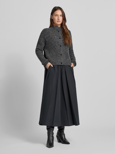 Kobiece model nosi kardigan rozpinany z stójką Model 'manzi' od Gestuz, krój relaxed fit, listwa guzikowa, długość tyłu 54 cm, długość rękawów 52 cm, widok całej sylwetki z przodu.