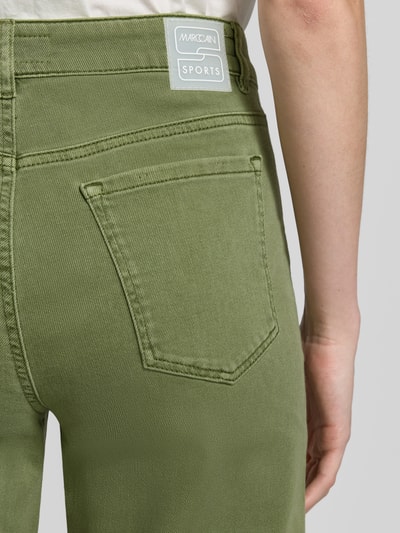Frauenmodel trägt Feminine Fit Jeans mit Fransen und Eingrifftaschen von Marc Cain aus Baumwoll-Elasthan-Mix in Olivgrün, Detailaufnahme Rückansicht.