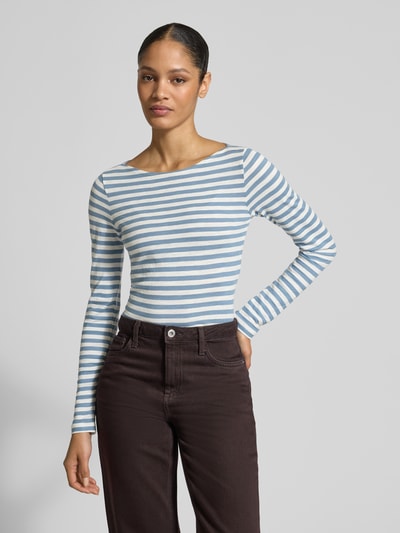 Frauenmodel trägt Regular Fit Langarmshirt aus reiner Baumwolle von Marc O’Polo mit blau-weißem Allover-Streifendesign, Logo-Print, U-Boot-Ausschnitt und langen Ärmeln aus weichem Material, Ganzkörperansicht von vorne.