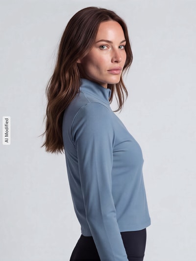 Frauenmodel trägt Slim Fit Sport-Langarmshirt mit Logo-Print von Under Armour in Blau vor grauem Hintergrund, Nahaufnahme Oberkörper, KI-modifiziertes Bild.