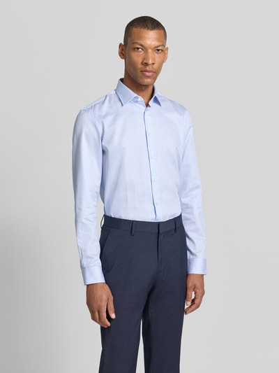 Männermodel trägt Slim Fit Business-Hemd mit Kentkragen von Jake*s, Reine Baumwolle, feine blaue Streifen, Ganzkörperansicht von vorne. Rückenlänge 78 cm, Schulterbreite 47 cm, Ärmellänge 66 cm, Knopfleiste, Sportmanschetten, abgerundeter Saum, verlängerter Rücken, Größe 39/40.