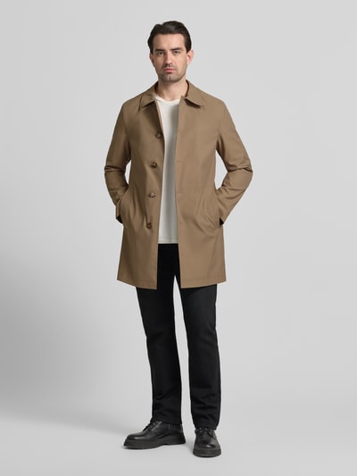 Männermodel trägt Mantel mit Knopfleiste von MCNEAL in Beige, lockerer Schnitt, Kentkragen, Eingrifftaschen, Ganzkörperansicht von vorne.