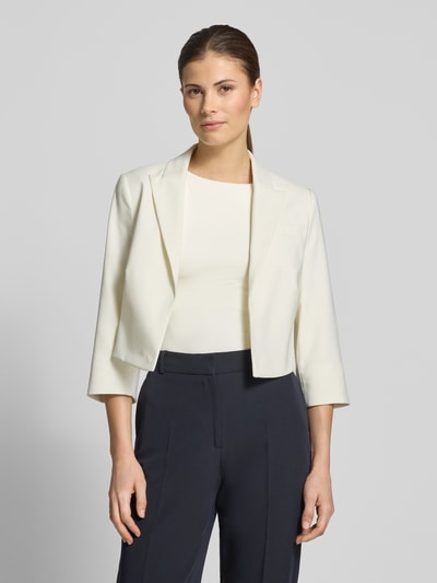 Vrouwenmodel draagt Cropped Blazer met Reverskraag van Betty Barclay, elastische materiaalmix, kort, open voorkant, reverskraag, 3/4-mouw, ruglengte maat 36: 41 cm, borstwijdte maat 36: 40 cm, mouwlengte maat 36: 44 cm, in crème en donkerblauw, eenvoudige vormen, gladde textuur, volledig lichaamsaanzicht van voren.