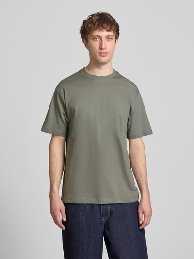 Männermodel trägt Relaxed Fit T-Shirt aus reiner Baumwolle Modell 'FRED LIFE' von Only & Sons, unifarben, Rundhals, Kurzarm, Ganzkörperansicht von vorne.