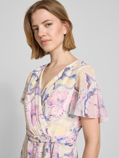 Frauenmodel trägt Midikleid mit floralem Allover-Print von Christian Berg Cocktail in zarten Pastelltönen, Tailliert, V-Ausschnitt, Falten-Optik, Kurzärmelig, abnehmbares Stoffband, Nahaufnahme Oberkörper.