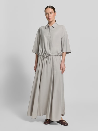 Kobiece modelka nosi Boxy Fit bluzkę z mieszanki modalu model 'LAINAY' od Drykorn, kolor jasnoszary, wykładany kołnierz, rękaw o dł. 3/4, tunel, długość tyłu w rozmiarze 36: 54 cm, długość rękawów w rozmiarze 36: 27 cm, zdjęcie całej sylwetki z przodu