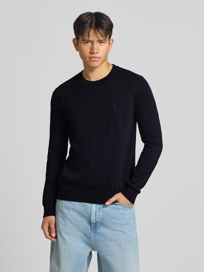 Männermodel trägt Regular Fit Pullover aus Baumwoll-Mix Modell 'San Celio-C' von HUGO Blue in Schwarz, helle Jeans, Ganzkörperansicht von vorne.