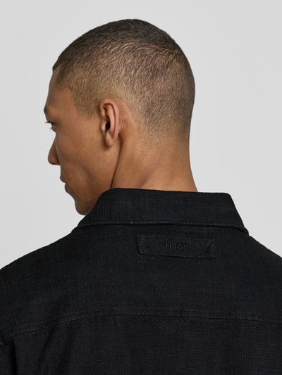 Männermodel trägt Regular Fit Jacke aus reiner Baumwolle Modell 'ECORD' von HUGO in Schwarz, sichtbarer Label Patch, Nahaufnahme Rückansicht.