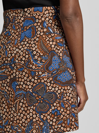 Vrouwenmodel draagt Ausgestellter Mini-Rock aus Baumwoll-Mix Modell 'FUNGO' van Weekend Max Mara, abstract all-over motief in bruin, blauw en wit, katoenmix materiaal, ritssluiting, detailopname heup.