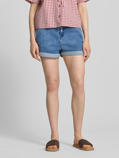 Frauenmodel trägt Straight Fit Shorts in Denim-Optik mit Viskose-Anteil von Apricot, blauer Baumwoll-Viskose-Mix, Eingriffstaschen, elastischer Bund, Knopf-Reißverschluss, Ganzkörperansicht von vorne.