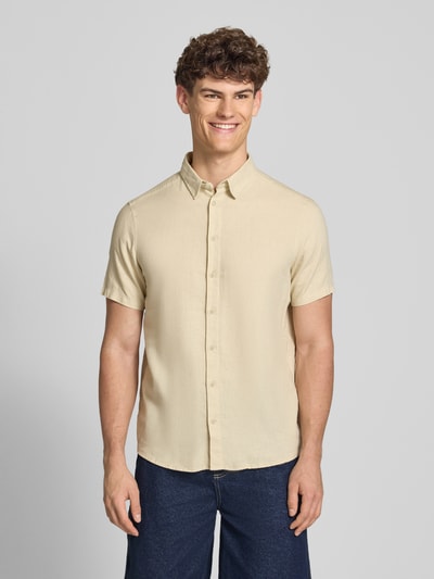 Männermodel trägt Slim Fit Leinenhemd mit Viskose-Anteil Modell 'Bobby' von Blend, Kentkragen, Kurzärmelig, Ganzkörperansicht von vorne. Rückenlänge bei Größe M: 75 cm, Schulterbreite: 38 cm, Ärmellänge: 23 cm. Helles Beige, glatte Textur, durchgehende Knopfleiste.