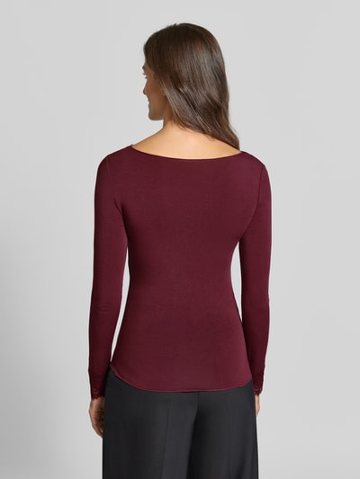 Modelka nosi bordową bluzkę z długim rękawem z dodatkiem wełny Slim Fit Langarmshirt aus Modal-Mix mit Woll-Anteil Modell 'SKYE' od VERO MODA, widok całej sylwetki z tyłu.