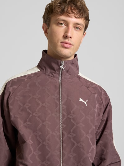 Männermodel trägt Trainingsjacke mit Reißverschluss und Logo von PUMA PERFORMANCE, Relaxed-Fit, Stehkragen, Nahaufnahme Oberkörper.
