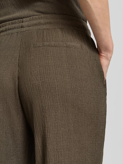Frauenmodel trägt Wide Fit Stoffhose mit Strukturmuster Modell 'Mileni' von OPUS in Braun mit elastischem Bund, Detailaufnahme Rückenbereich.