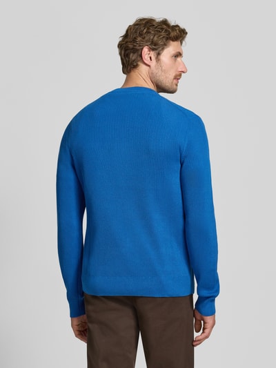 Männermodel trägt Regular Fit Strickpullover aus Mieszanka bawełny von MCNEAL, kolor niebieski, wykończenia elastyczne, widok całej sylwetki od tyłu. Długość tyłu 65 cm, długość rękawów 56 cm, rozmiar M.