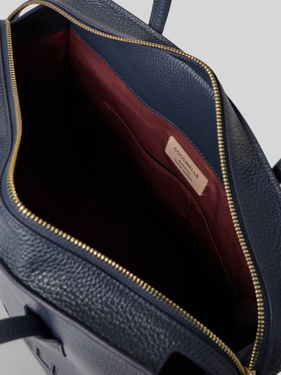 Produktfoto, saszetka Pochette mit Tragehenkeln und Logo Modell 'MYRTHA26' von Coccinelle, granatowy kolor, struktura skóry, główna przegroda z zamkiem błyskawicznym, logo, szerokość w rozmiarze 1: 36 cm, długość w rozmiarze 1: 28 cm, głębokość w rozmiarze 1: 13 cm, długość paska na ramię w rozmiarze 1: 67 cm