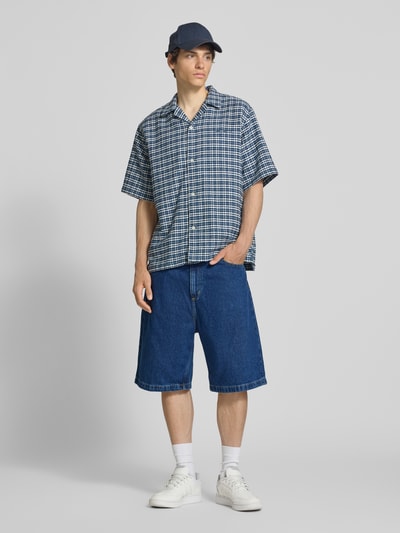 Männermodel trägt Jeansshorts mit Eingrifftaschen Modell 'Brandon' von Carhartt Work In Progress, Reine Baumwolle, Relaxed-Fit, Ganzkörperansicht von vorne.