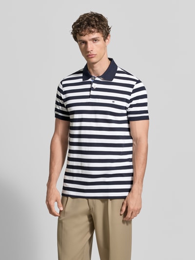 Männermodel trägt Modern Fit Poloshirt mit Logo-Stitching von Christian Berg Men aus Reine Baumwolle, Polokragen, 2-Knopfleiste, Rückenlänge 73 cm, Ganzkörperansicht von vorne.