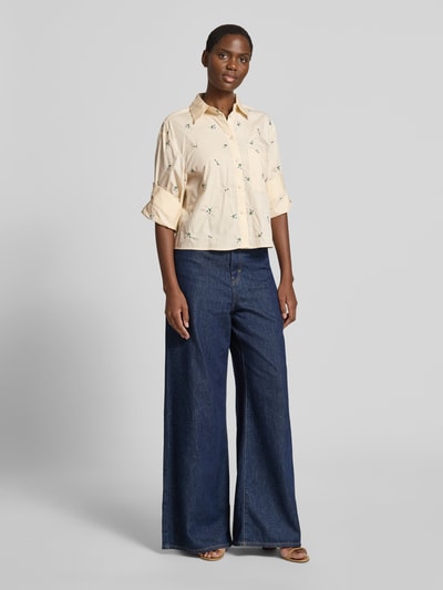 Frauenmodel trägt Regular Fit Bluse mit Stitchings Modell 'LOVELY' von Mango, cremefarben, Hemdblusenkragen, Brusttasche, Ganzkörperansicht von vorne. Rückenlänge bei Größe S: 52 cm, Ärmellänge bei Größe S: 46 cm.
