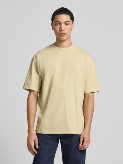 Mannelijk model draagt Oversized Fit T-shirt met logo-stitching van Pegador in beige, puur katoen, ronde hals, ruglengte 71 cm, vooraanzicht, nahaufnahme bovenlichaam.