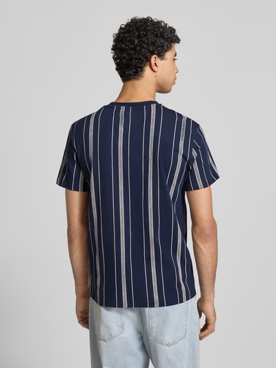 Männermodel trägt Regular Fit T-Shirt aus reiner Baumwolle von Tommy Jeans, Optik:Allover-Muster, Ganzkörperansicht Rückansicht.
