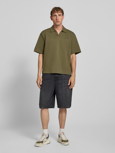 Männermodel trägt Regular Fit poloshirt met logo model 'Eddie' van Redefined Rebel, katoenmix, V-hals, heren, ruglengte maat M 73 cm, ganzlichaamsvooraanzicht.