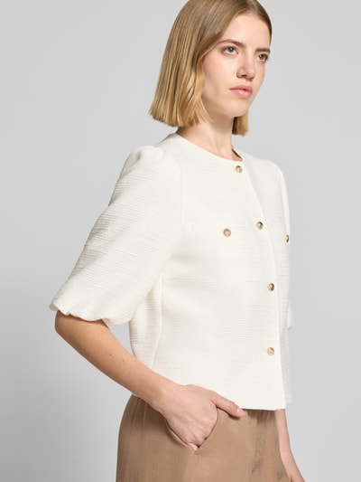Kobiece model prezentuje Regular Fit Blazer aus Viskose-Mix mit Puffärmeln von More & More, kremowy, fakturowany wzór, mieszanka wiskozy i bawełny, bufiaste rękawy, okrągły dekolt, listwa guzikowa, długość tyłu w rozmiarze 36: 46 cm, szerokość w rozmiarze 36: 44 cm, długość rękawów w rozmiarze 36: 35 cm, ujęcie z przodu, do pasa.